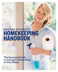 The cover of Martha Stewart's Homekeeping Handbook, showing her with blonde hair and a light blue button up shirt, smiling, and holding a spray bottle of blue liquid and a roll of paper towels.